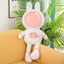 This pink space rabbit plush toy, dressed in a spacesuit, is soft and adorable. Placed on a yellow sofa, this space-themed plush toy is perfect as a children's gift and home decoration.