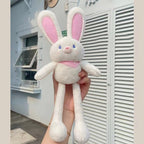 A white plush rabbit with ears and legs that can be pulled to make them longer or shorter