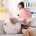 Girl hugging soft cuddly rabbit pillow plush toys, round bunny throw cushions in pink and gray, cozy plush pillow for relaxing on sofa, perfect gift for girls and children