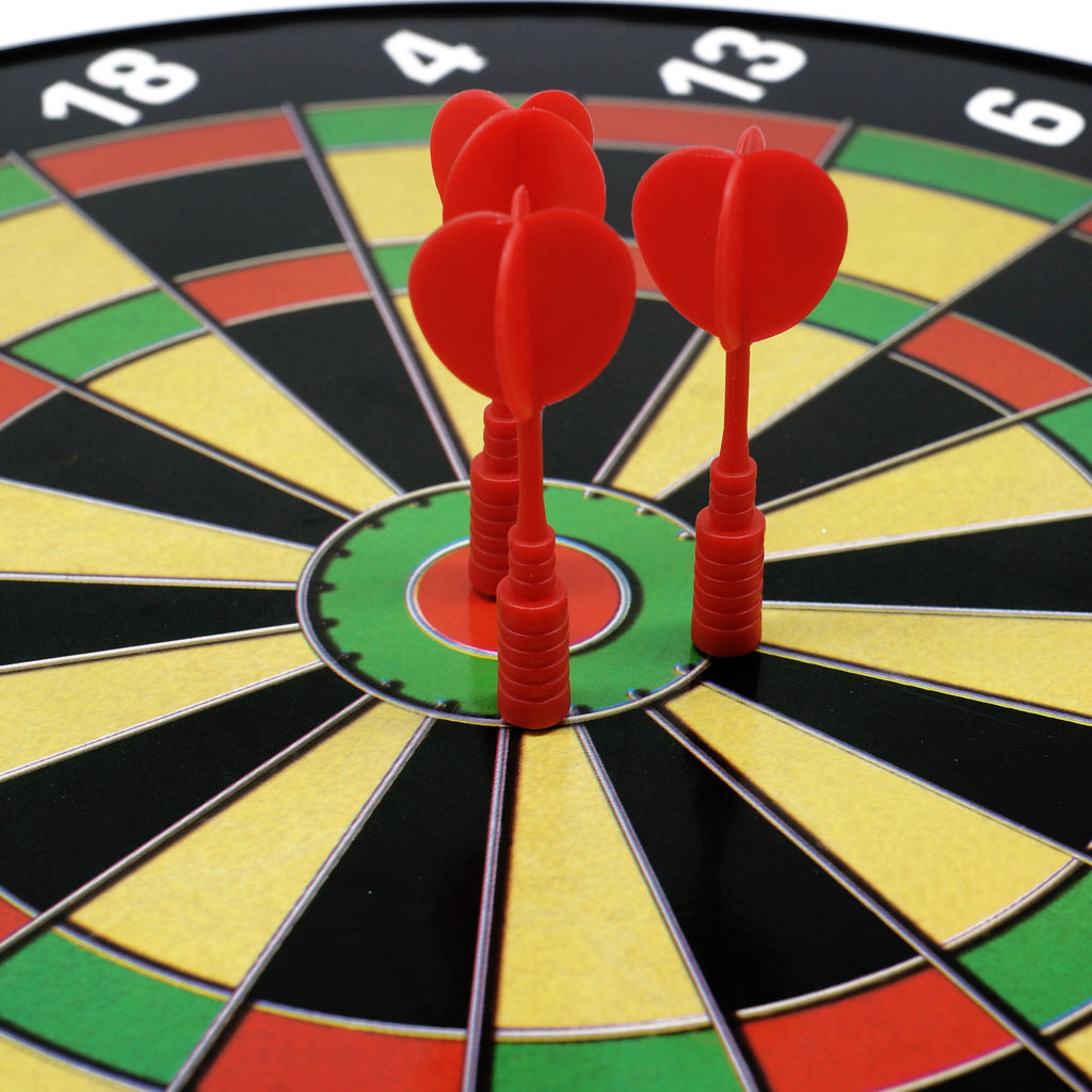 Close-up of 3 red magnetic darts stuck to the bullseye of a kids magnetic dart board.