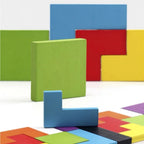 Close-up of colorful 3D wooden tetris puzzle pieces standing next to a partially filled puzzle board.