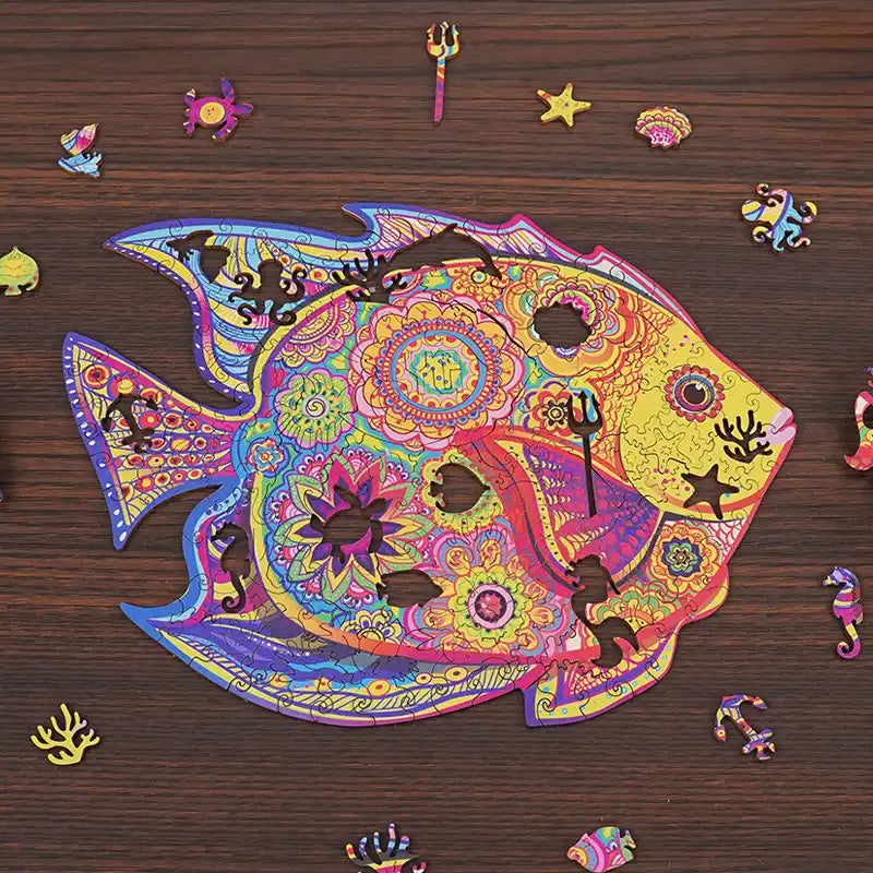 Colorful fish-shaped wooden puzzle with ocean-themed whimsy pieces including seahorse, starfish, anchor, and coral.