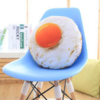 Fried egg plush pillow placed on modern blue chair, funny food shaped stuffed seat cushion, creative home decoration for bedroom and office