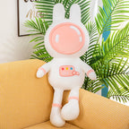 This pink space rabbit plush toy, dressed in a spacesuit, is soft and adorable. Placed on a yellow sofa, this space-themed plush toy is perfect as a children's gift and home decoration.