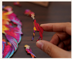 Hand holding a colorful giraffe-shaped wooden puzzle piece, with a vibrant lion puzzle visible in the background.